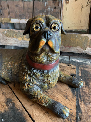 A recumbent pug dog figure with glass eyes