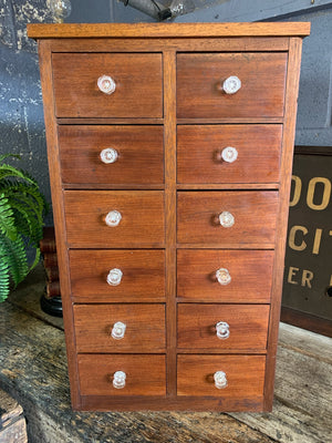 A bank of 12 apothecary drawers