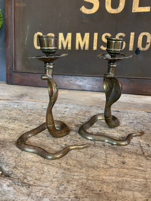 A pair of small Indian or North African cobra candlesticks