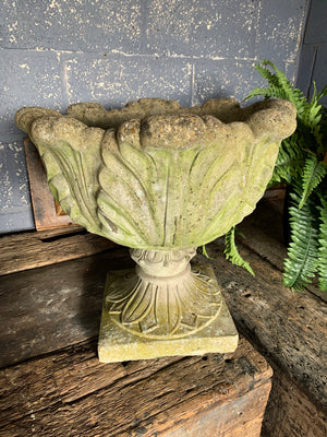 A pair of large tulip or acanthus pattern cast stone urns