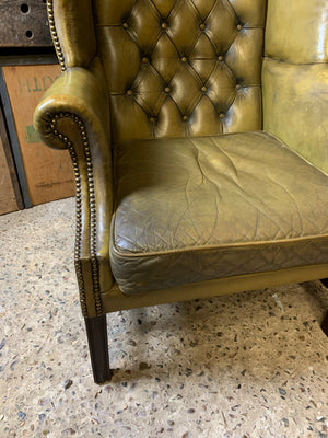 An apple-green wingback Chesterfield chair