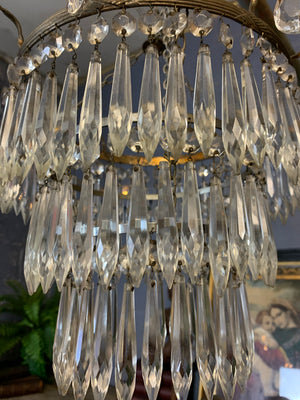 A large gilt three tier crystal icicle droplet chandelier