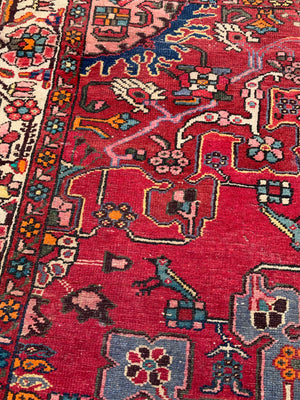 A large hand woven Persian red ground rectangular rug with bird motifs