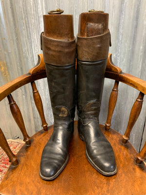 A pair of black leather riding boots with wooden lasts