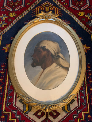 A watercolour portrait of a man in an oval gilt frame