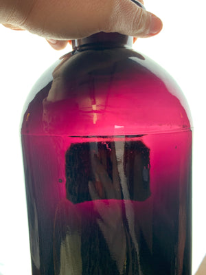 A pair of very large amethyst glass apothecary bottles