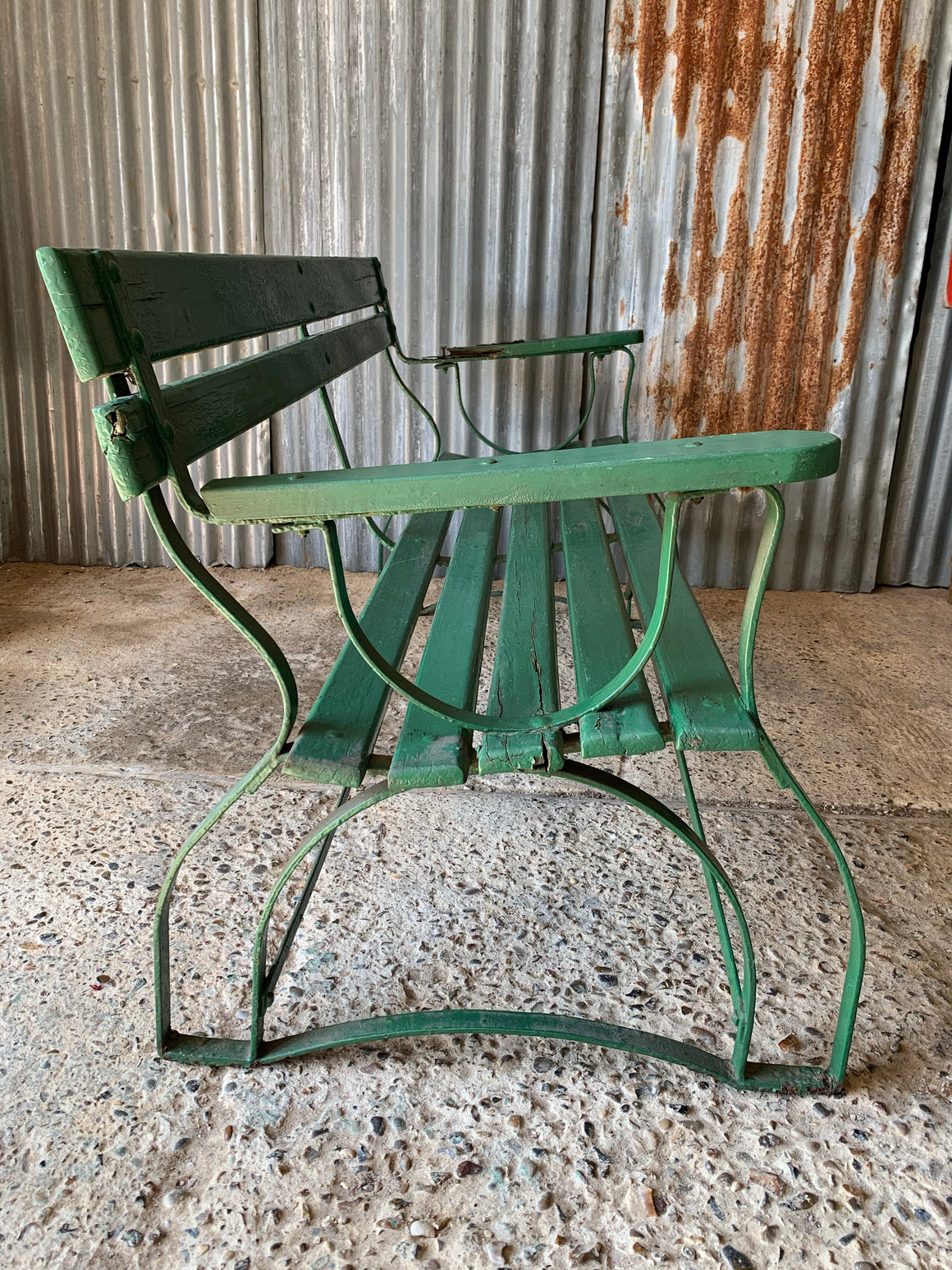A green cast iron and wooden garden bench