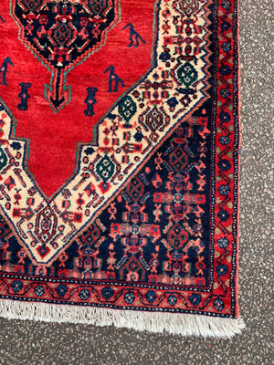 A hand woven Persian red ground rectangular Senneh rug