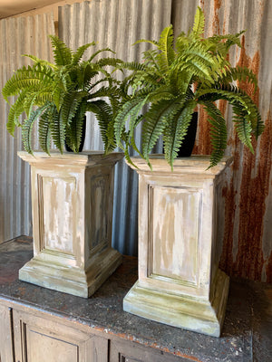 A pair of white pedestal stands