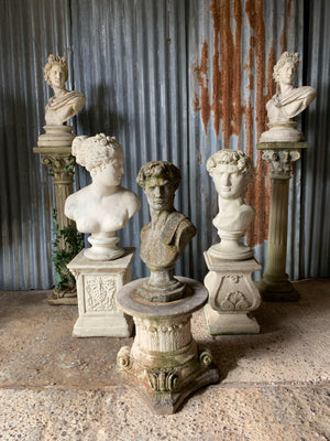 A cast stone bust of Venus (or Aphrodite) on a pedestal