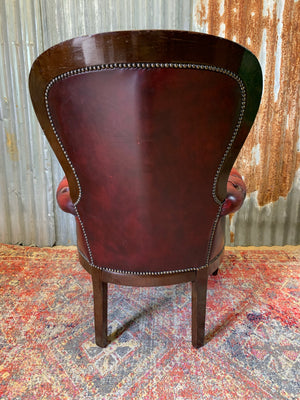 A red leather button back armchair