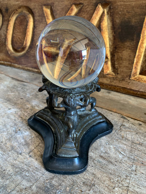 A fortune teller's crystal ball on a bronze and marble stand
