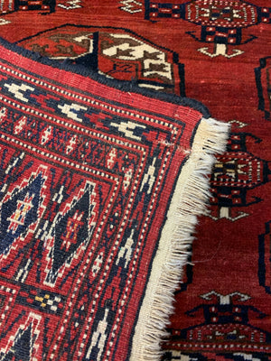 A hand woven Persian red ground rectangular rug with multiple lozenges