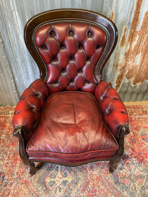 A red leather button back armchair