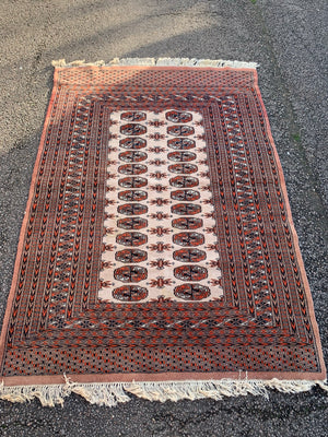 A rectangular beige and orange ground Persian Bokhara rug