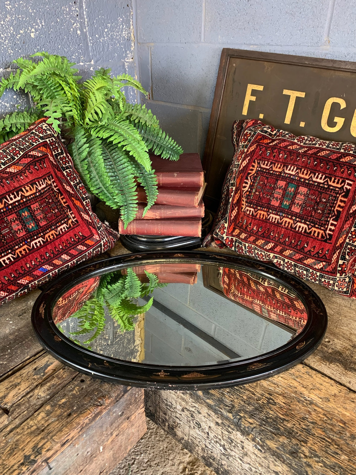 An oval black lacquered Chinoiserie mirror