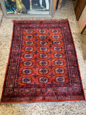 A Persian orange-red ground rectangular rug with multiple lozenge