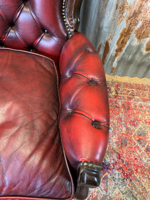 A red leather button back armchair