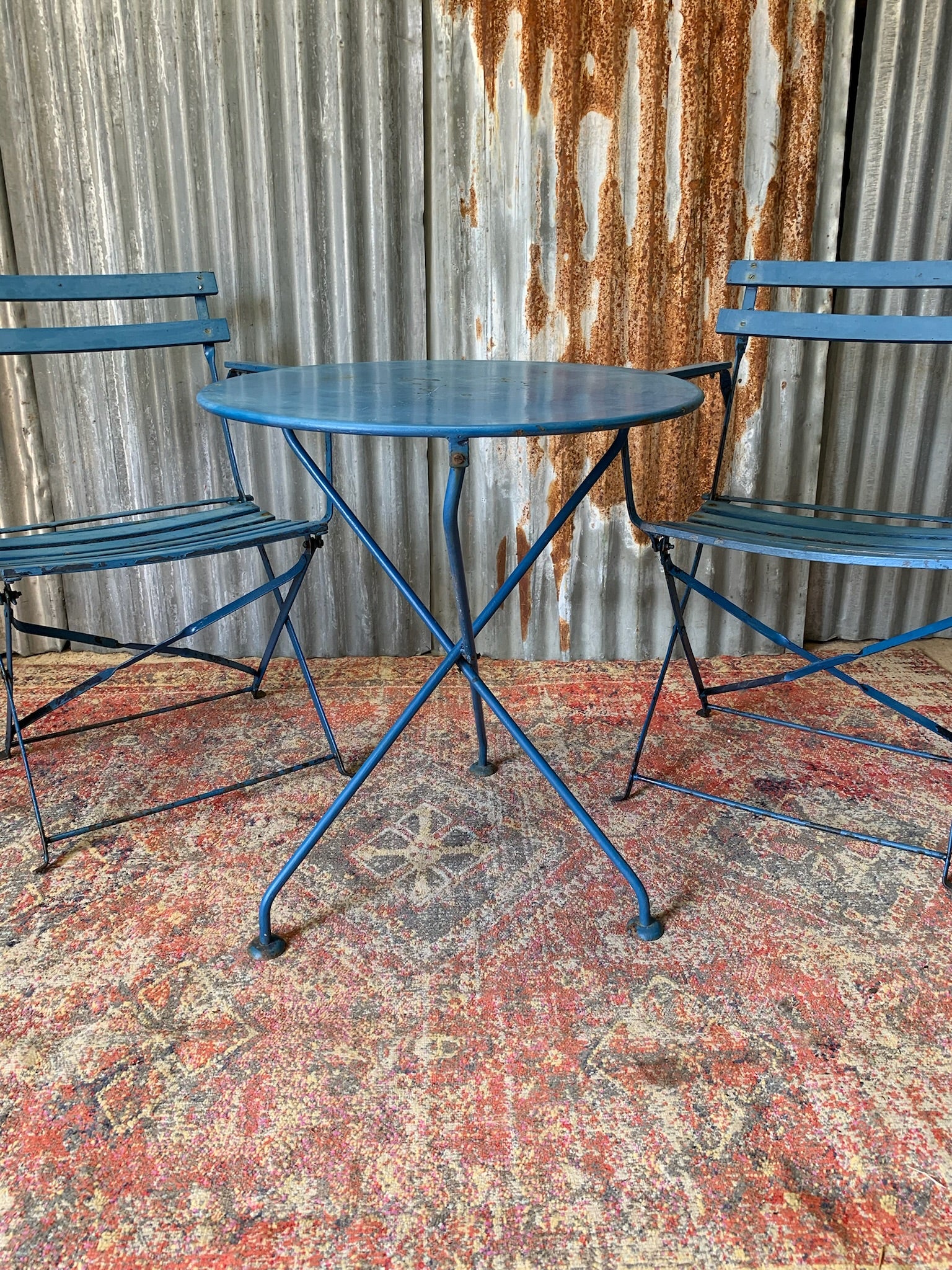 A blue cast iron French garden table and two chairs Belle and