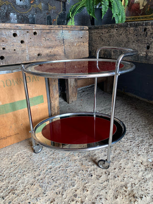 An Art Deco two-tier drinks trolley with red glass on castors