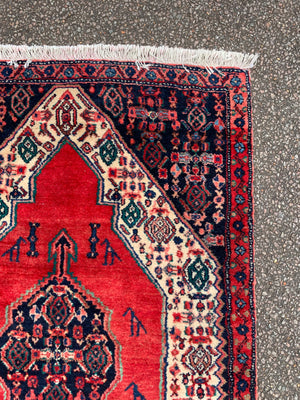 A hand woven Persian red ground rectangular Senneh rug
