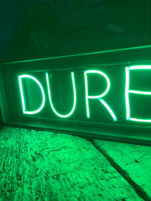 An illuminated Durex sign