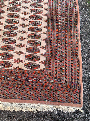 A rectangular beige and orange ground Persian Bokhara rug