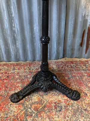 A black cast iron bistro table with marble top