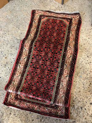 A long pink and red ground Persian Hosseinabad runner rug