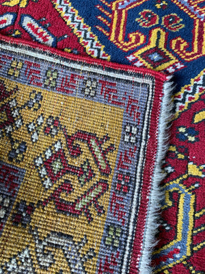 A rectangular Persian rug- red ground with yellow accents