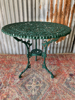 A green Victorian style table and two chairs set