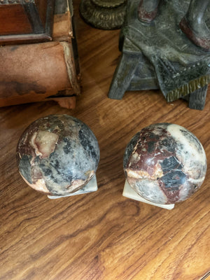 A pair of Grand Tour marble balls on stepped stands