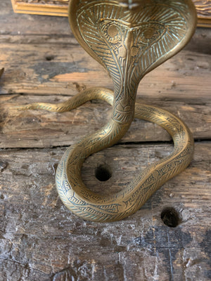 A pair of Indian or North African brass cobra candlesticks