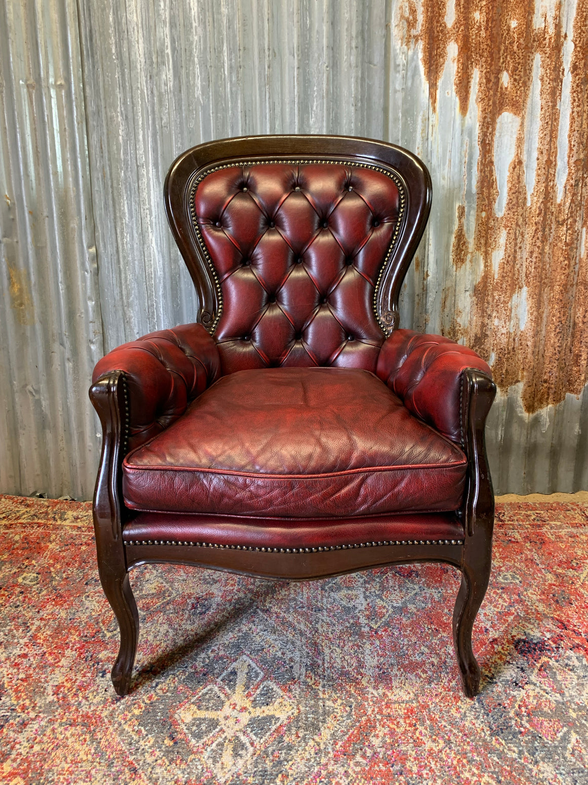 A red leather button back armchair
