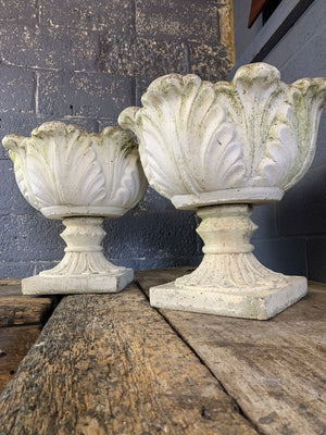 A pair of acanthus pattern cast stone urns