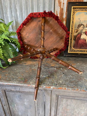 An octagonal red velvet faux bamboo gypsy table
