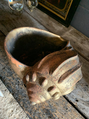 A large terracotta seashell planter