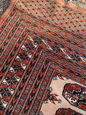 A rectangular beige and orange ground Persian Bokhara rug