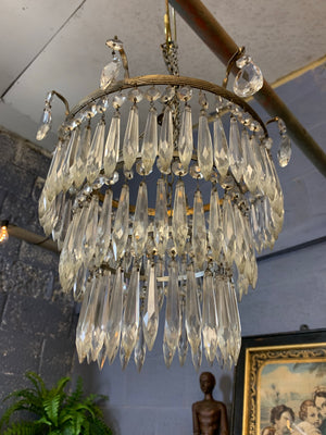 A large gilt three tier crystal icicle droplet chandelier