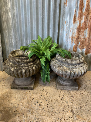 A pair of large gadrooned cast stone urns