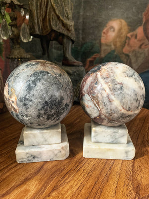 A pair of Grand Tour marble balls on stepped stands
