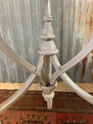 A white cast iron bistro garden table with wooden top