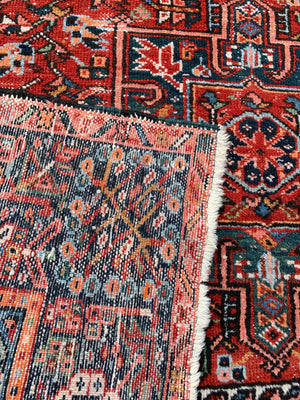 A large rectangular red ground Persian rug