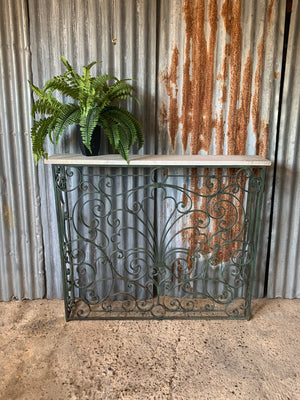 A tall cast iron strapwork console table with marble top