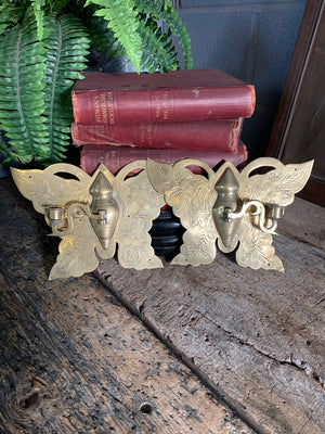 A pair of large brass butterfly wall sconces