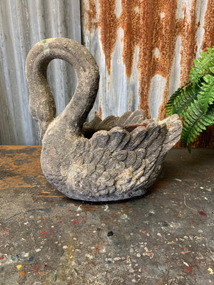 A large terracotta swan planter