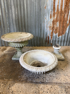 A pair of large gadrooned egg and dart cast stone urns