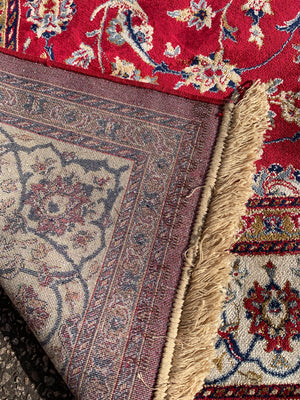 A large red ground Persian rectangular rug