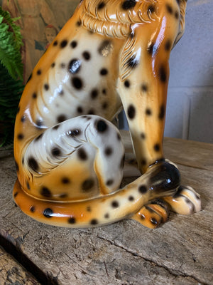A large ceramic seated leopard statue