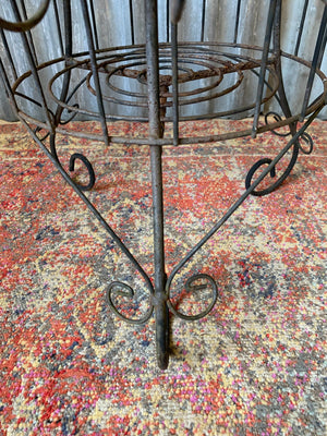 A three-tiered black wire work plant stand